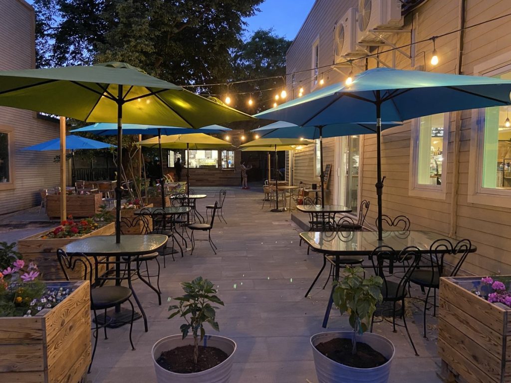 Terrasse éclairée en soirée à la crèmerie du QG